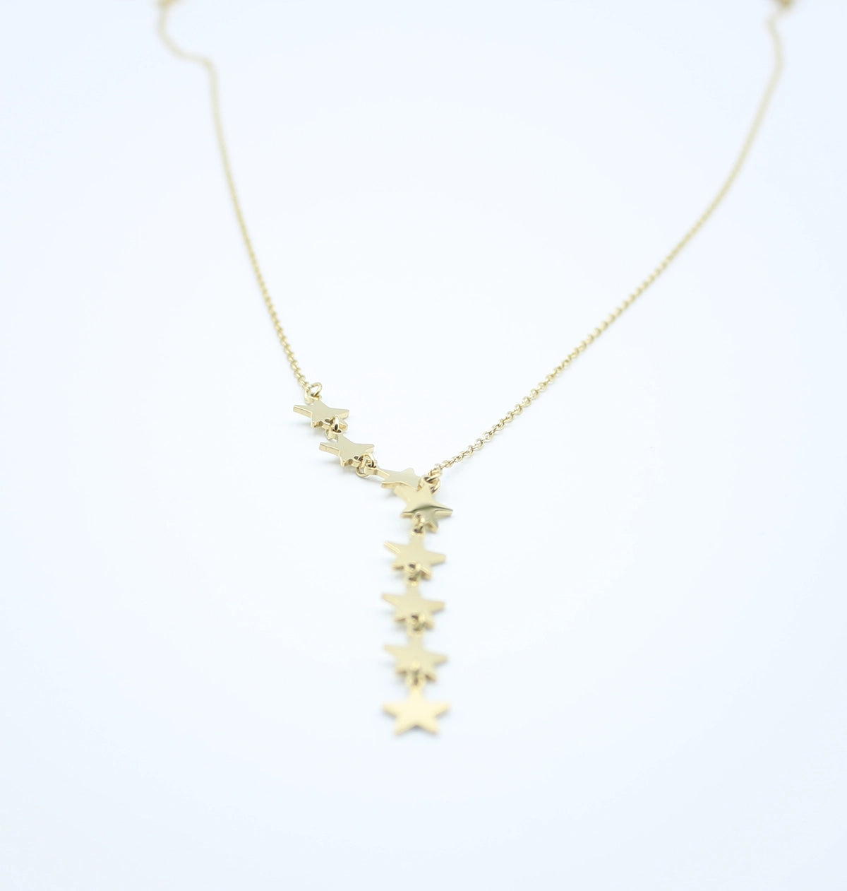 alt: Collar dorado con colgante de estrellas en acero inoxidable, diseño moderno y elegante.