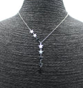 Collar de acero inoxidable plateado con estrellas, presentado sobre busto negro.