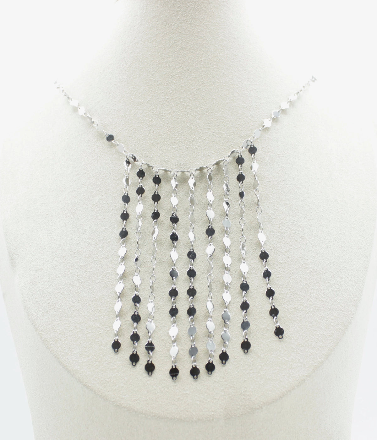 Collar Fireflies acero inoxidable plateado en un expositor blanco, diseño moderno largo sobre el pecho, destellos en todo el conjunto. - delacabra