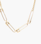 Collar dorado ajustable de acero con diseño de imperdibles, joya moderna y minimalista.