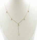 Collar Isla acero inoxidable dorado en busto, elegante y sutil, tiene una caída frontal que termina en una circonita blanca, perfecto para usarse en cuellos V - delacabra