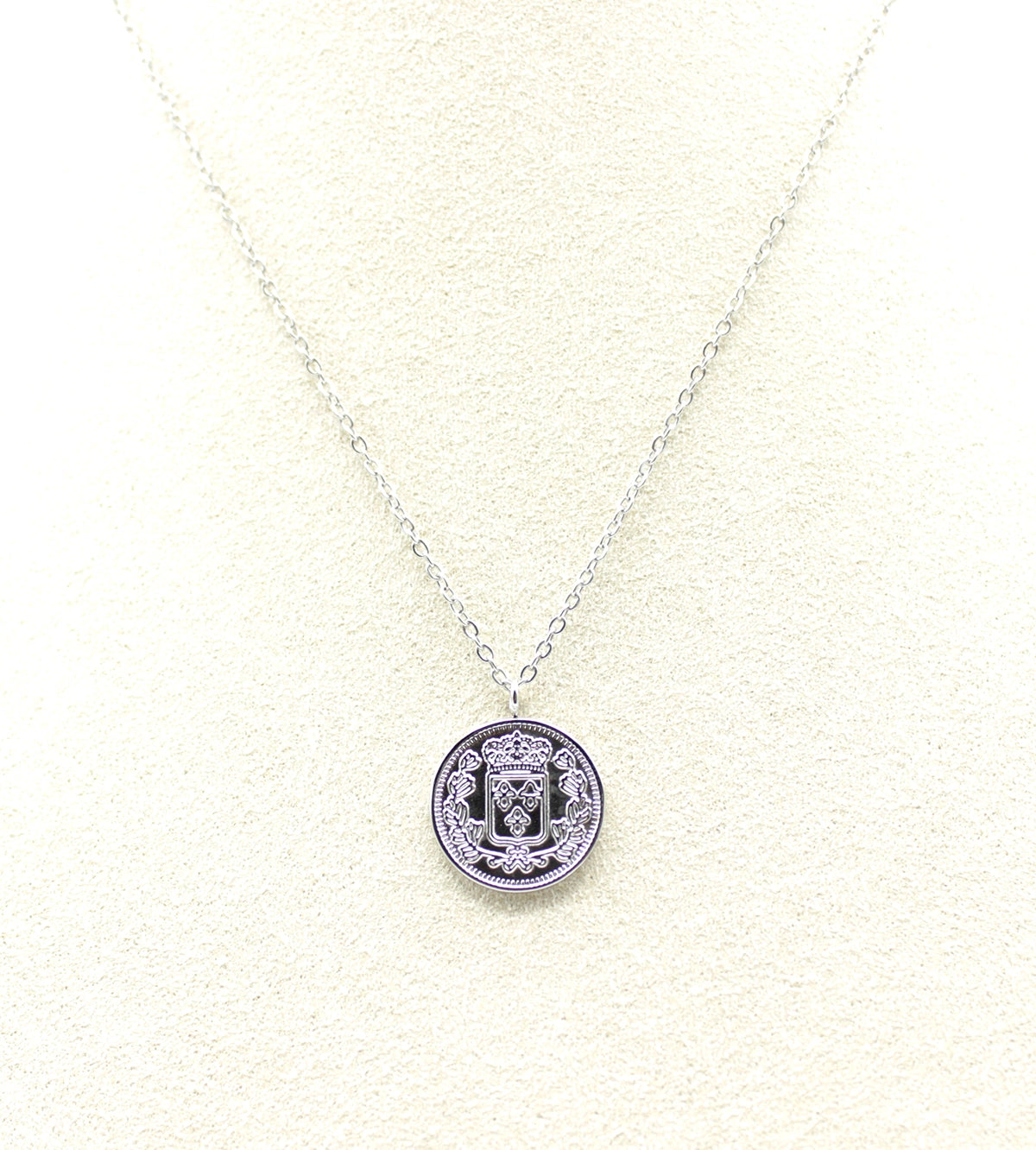 Collar Medaillon acero inoxidable plateado detalle del reverso del colgante muestra un escudo heráldico coronado, acabado brillante, sobrio y sutil. - DELACABRA