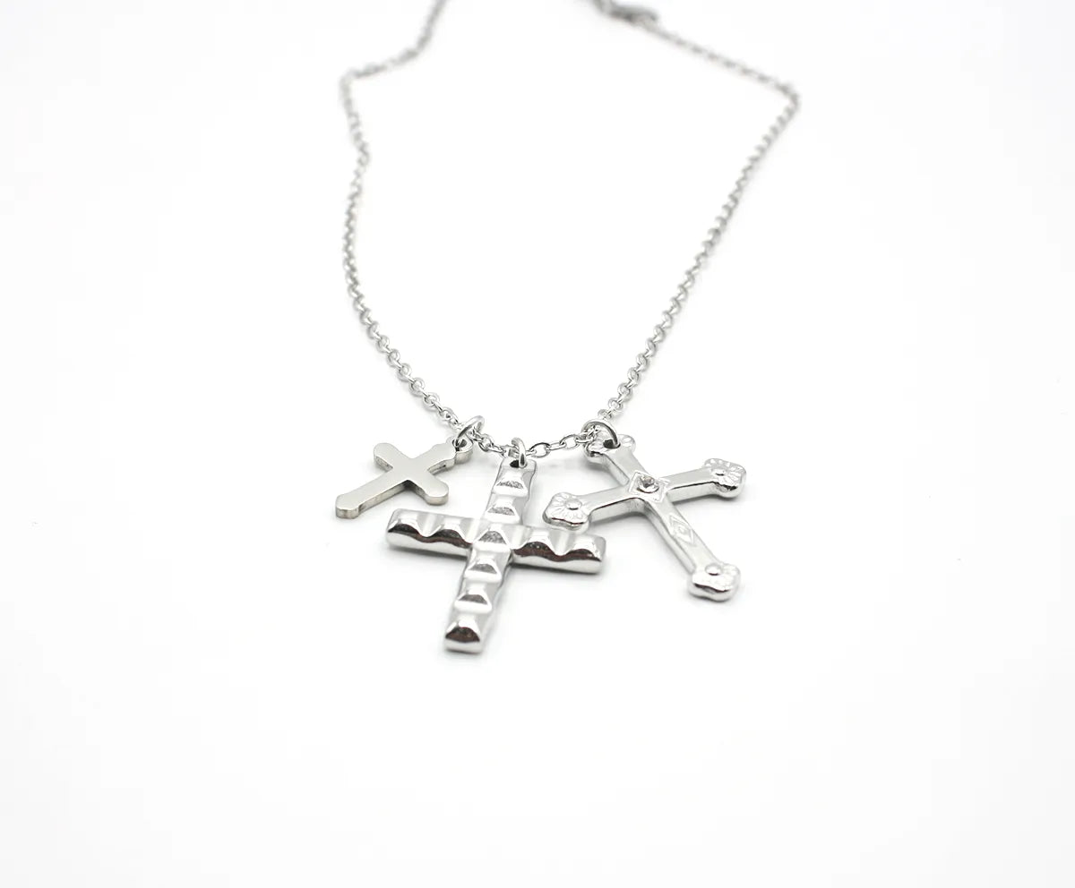 Collar de acero inoxidable plateado con tres dijes de cruces, joya hipoalergénica moderna.