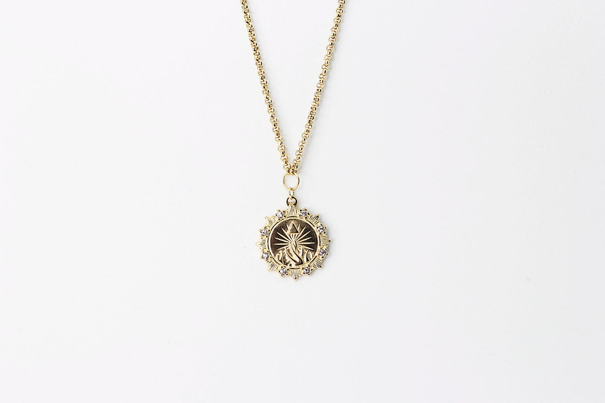 Collar Olympus acero inoxidable dorado, colgante de motivos tridimensionales, pirámide, fuego y mucha luz, marco decorado estilo insignia, ideal para destacar sobre prendas lisas.- DELACABRA