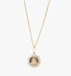 Collar de acero inoxidable dorado con dije redondo estilo medalla grabada y borde decorativo.