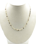 Collar Zaira acero inoxidable dorado luce en un busto blanco, pequeños circulos unidos por eslabones, discreto, sencillo y elegante. - delacabra