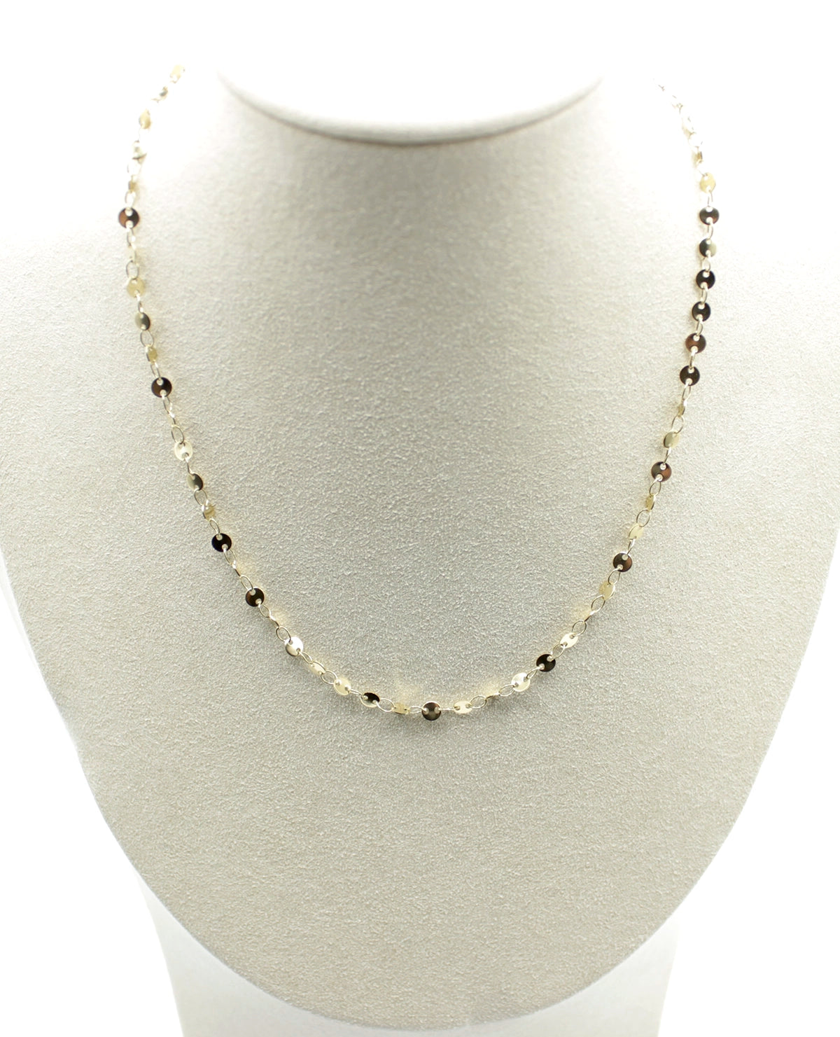 Collar Zaira acero inoxidable dorado luce en un busto blanco, pequeños circulos unidos por eslabones, discreto, sencillo y elegante. - delacabra
