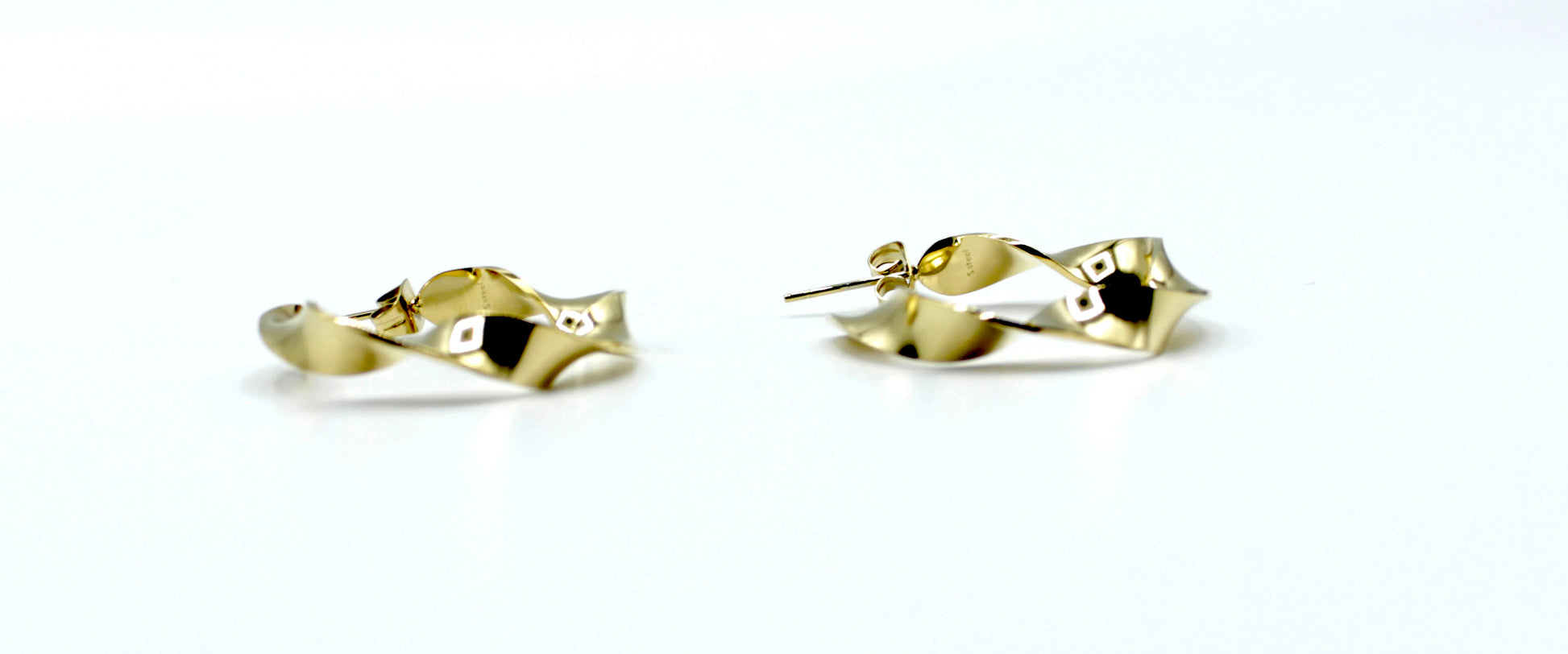 Pendientes River doradoss de aro abierto con diseño orgánico retorcido, fabricados en acero inoxidable hipoalergénico y resistente al agua.