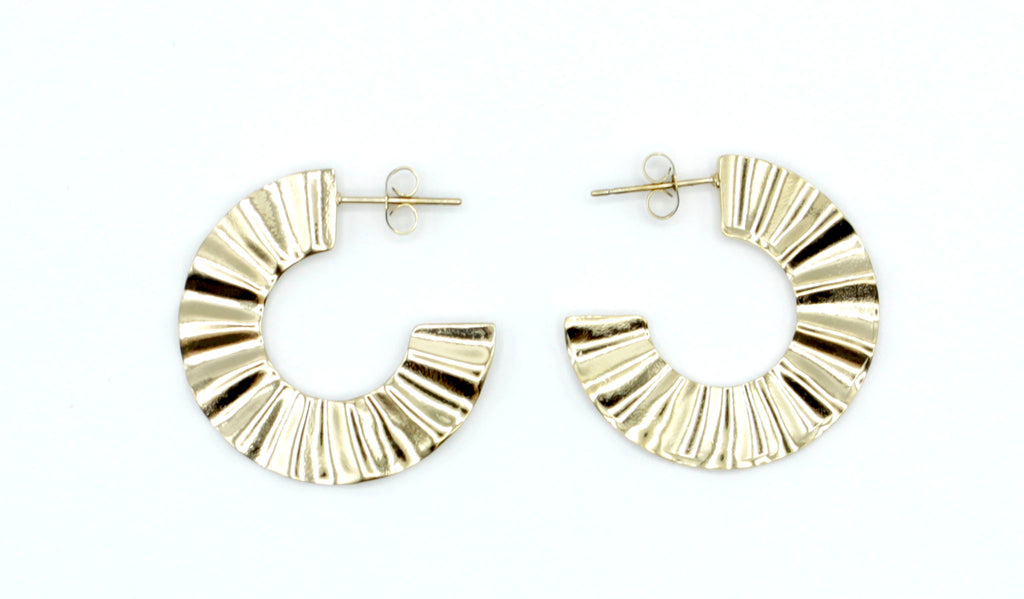 Pendientes de aro Sur en color dorado con relieve plisado, fabricados en acero inoxidable hipoalergénico, resistentes al agua y muy duraderos. Cierre de presión. DELACABRA