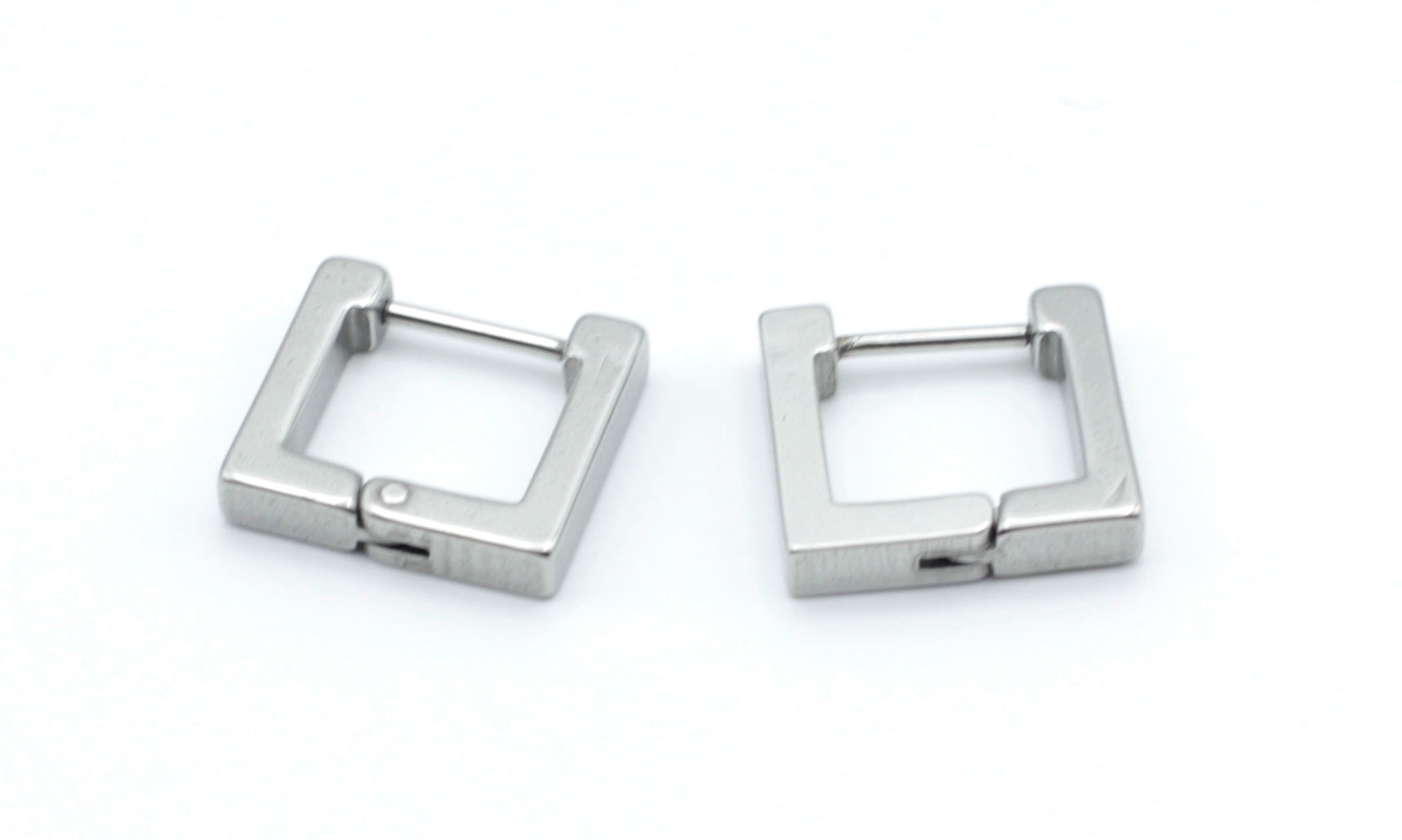 Detalle de los Pendientes Square en color plateado, fabricados en acero inoxidable hipoalergénico, resistentes al agua y de gran durabilidad. Cierre de bisagra fácil de usar. DELACABRA