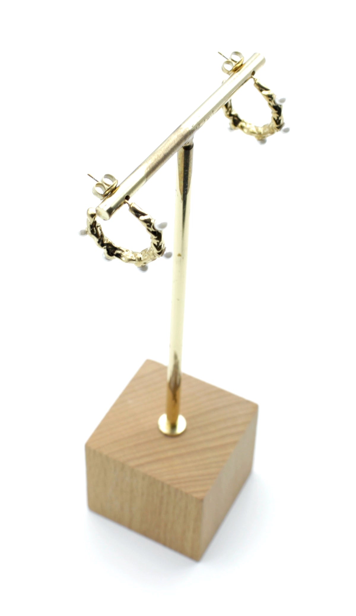 Pendientes Blanca de aro dorado en acero inoxidable hipoalergénico, resistentes al agua, con textura orgánica y detalles de perlas, presentados en expositor.