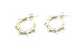 Pendientes Blanca de aro dorado en acero inoxidable hipoalergénico y resistente al agua, diseño irregular con perlas decorativas y cierre mariposa.