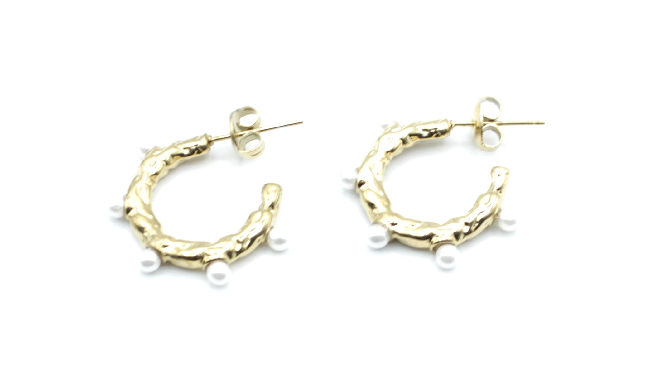 Pendientes Blanca de aro dorado en acero inoxidable hipoalergénico y resistente al agua, diseño irregular con perlas decorativas y cierre mariposa.