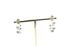 Aros Pearly dorados decorados con perlas blancas, acero inoxidable hipoalergénico y resistente al agua, presentados en expositor.