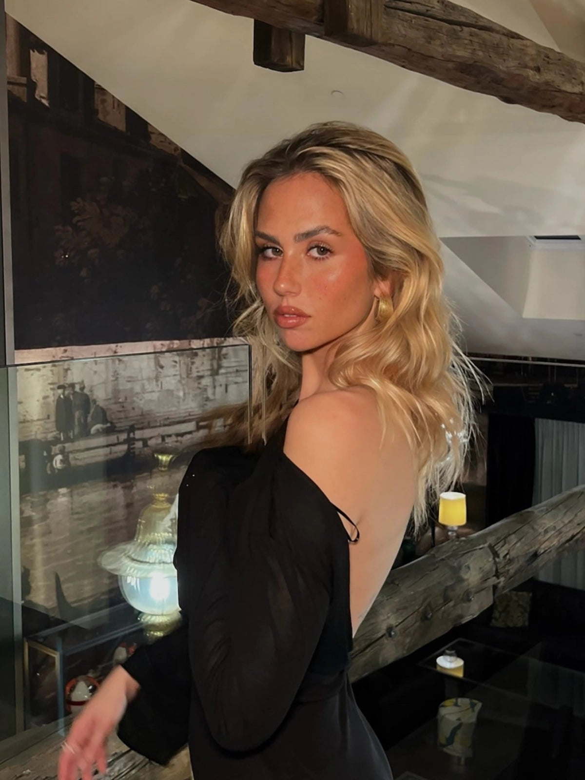 Mujer rubia con pendientes medio aro Wild en dorado, diseño martillado con cierre mariposa -DELACABRA