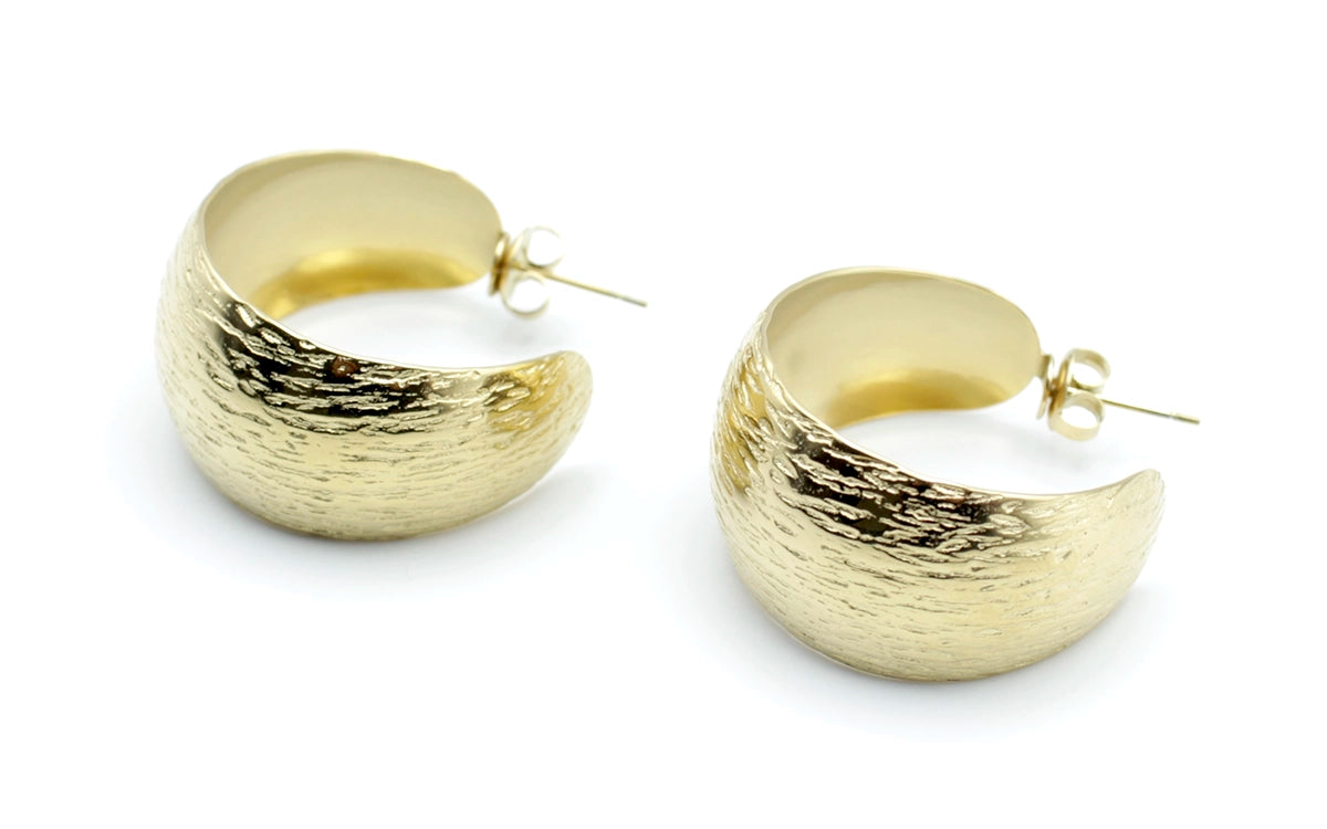 Pendientes medio aro Wild dorados con textura martillada, imagen en vista lateral para resaltar el grosor -DELACABRA