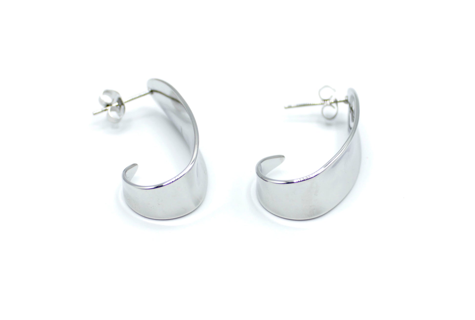 Pendientes Costa plateados de diseño curvado ancho, elaborados en acero inoxidable hipoalergénico, resistentes al agua y de gran durabilidad. DELACABRA