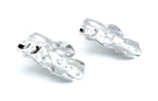 Pendientes Lys plateados de acero inoxidable en perspectiva lateral, diseño ondulado de superficie brillante, hipoalergénicos, resistentes al agua y duraderos - DELACABRA