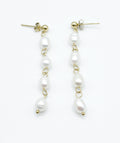 Pendientes Perle largos en acabado dorado con perlas blancas engarzadas, estilo minimalista y atemporal, hipoalergénicos y resistentes al agua – DELACABRA