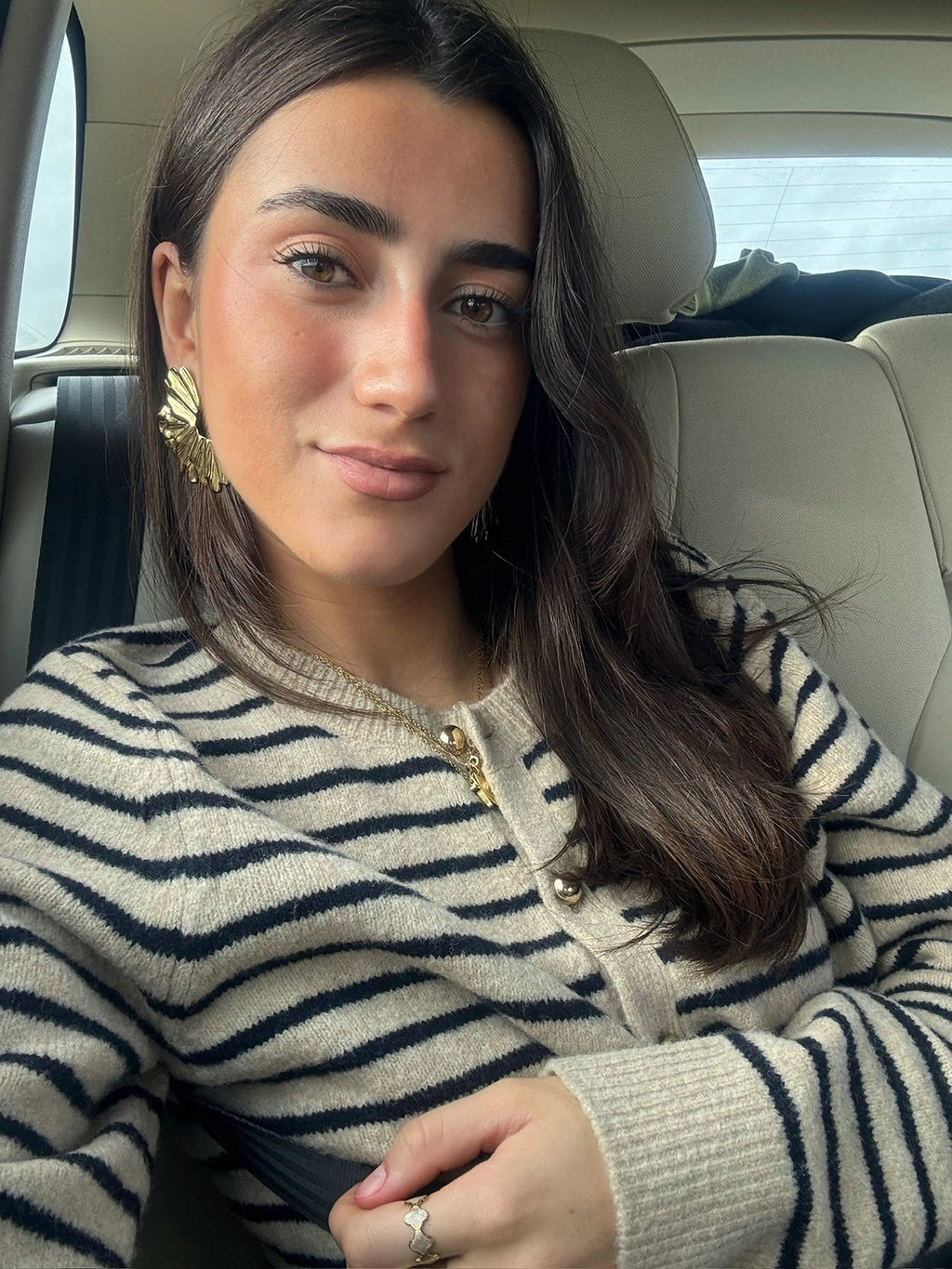 Mujer con pendientes Pétalos dorados de acero inoxidable, diseño llamativo de inspiración orgánica, hipoalergénicos, resistentes al agua y de cierre presión mariposa - DELACABRA