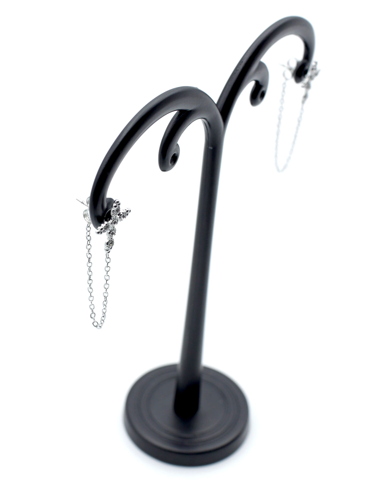 Pendientes Santo acero inoxidable plateado en expositor negro, diseño inspirado en la cruz que da un carácter místico y espiritual al pendiente. - DELACABRA