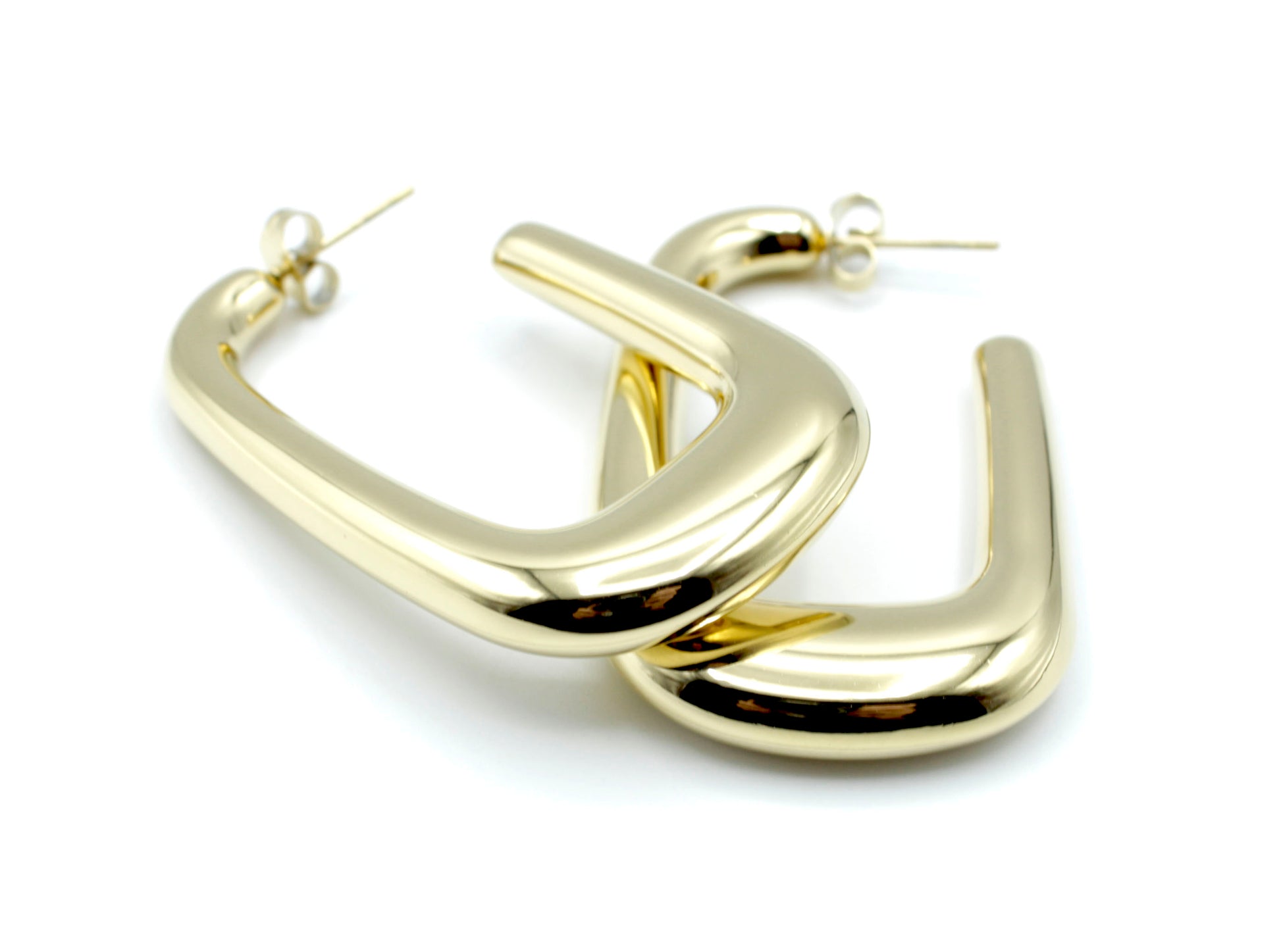 Mujer luciendo pendientes Sunlight dorados de acero inoxidable, diseño rectangular llamativo y elegante -DELACABRA