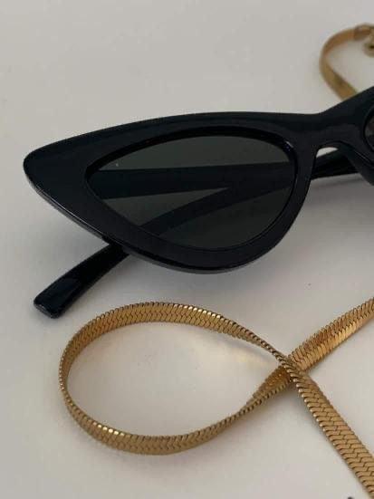 Collar dorado de acero inoxidable junto a gafas de sol negras estilo cat eye sobre fondo claro.
