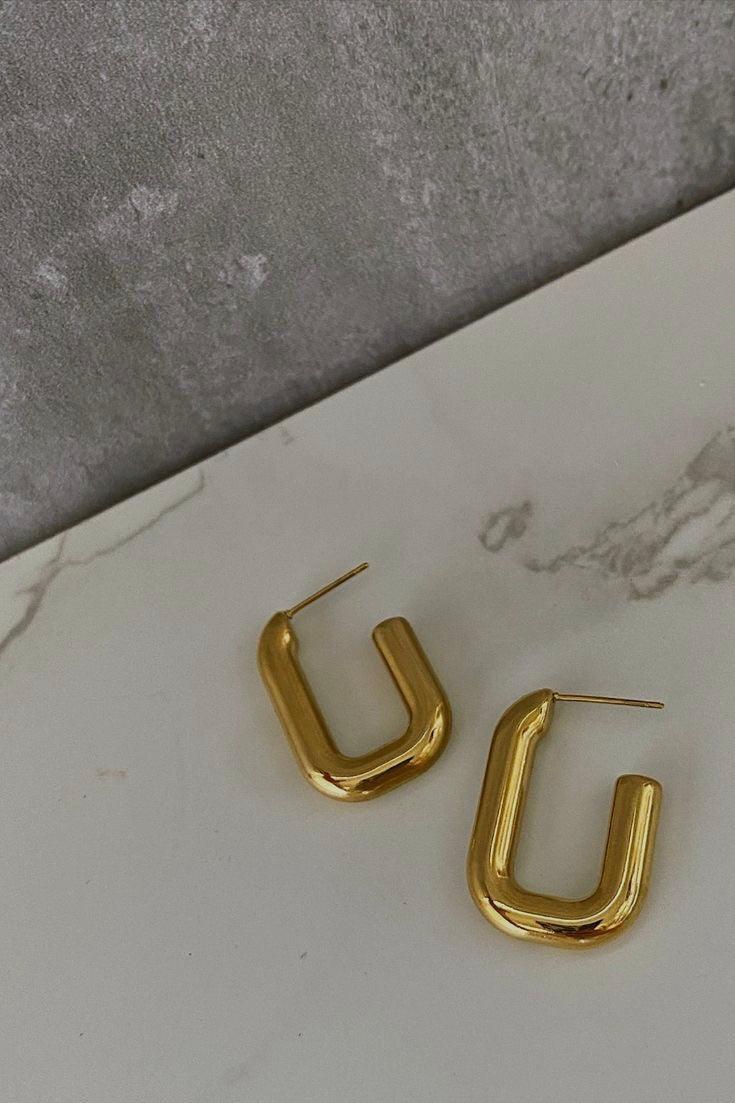 Pendientes de Aro Nora acero inoxidable dorado con forma de rectángulo con bordes redondeados con corte en una esquina dando un toque moderno, cierre mariposa, acabado dorado. - delacabra